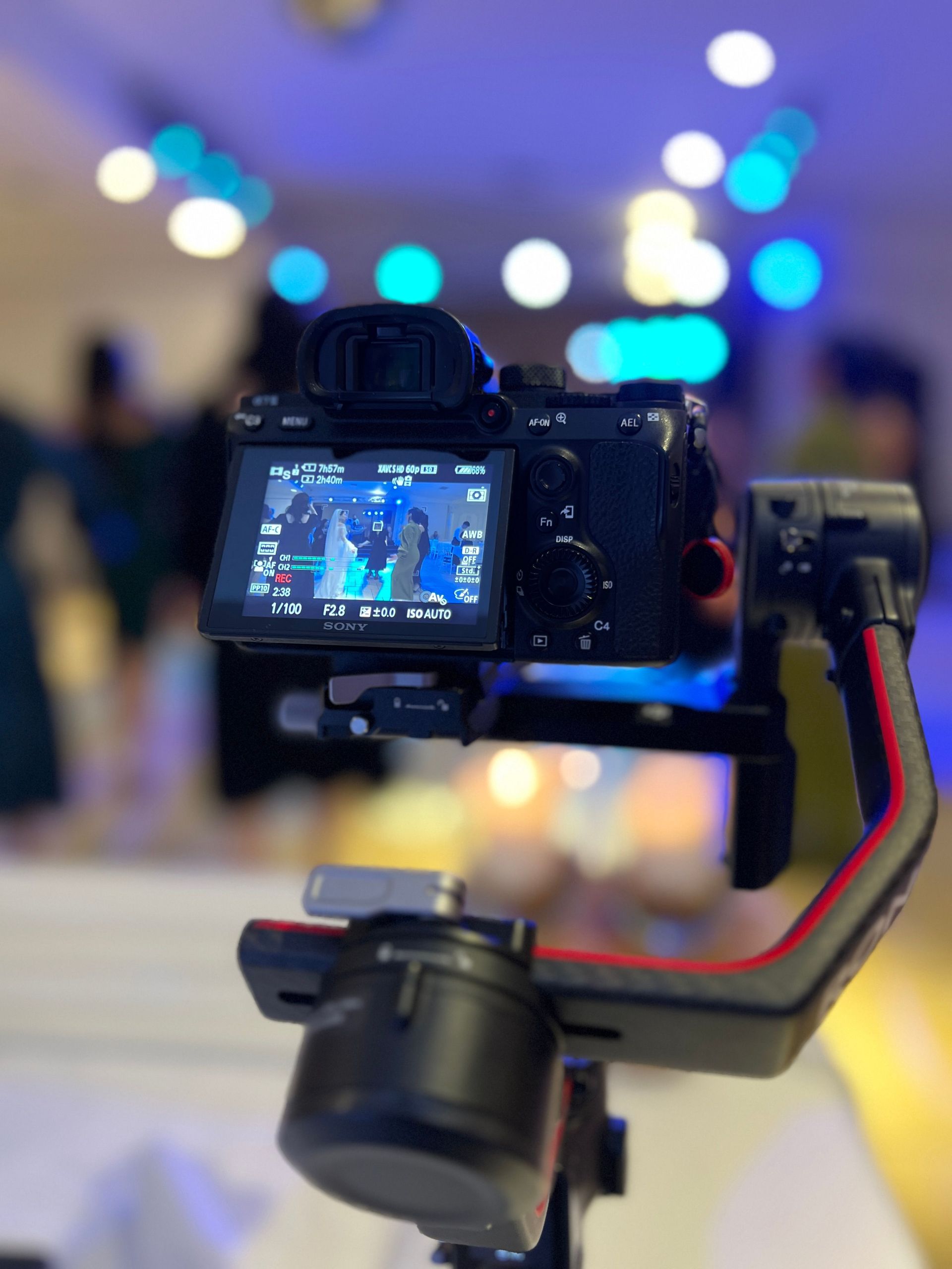 Close-up of a professional camera mounted on a gimbal, capturing a vibrant setting.